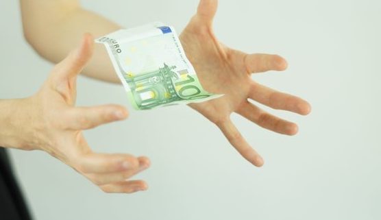 Frauenhände fangen Geld auf