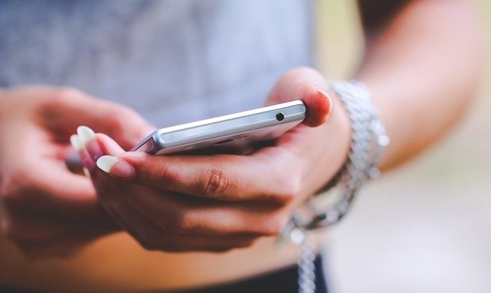 Frau hält Handy in Hand