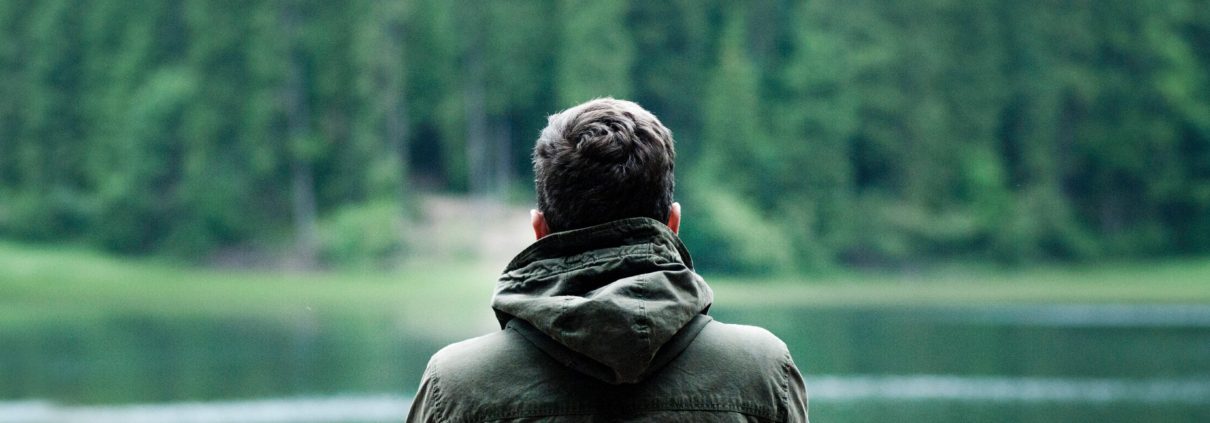 Mann sitzt am See