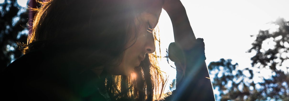 Frau streicht sich mit Hand durchs Haar